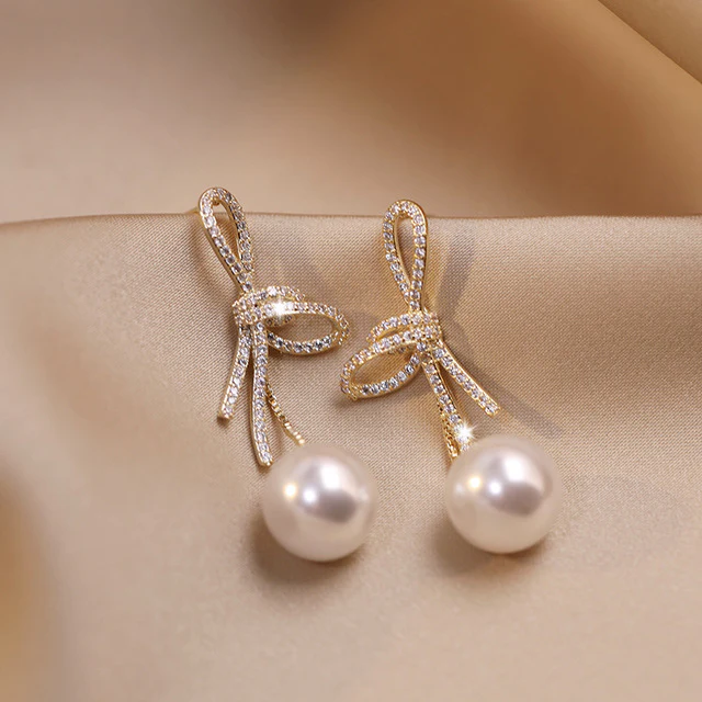 Gold Bow Pearl Earrings with a Shiny Finish